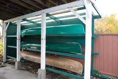 a large green train sitting on top of a wooden platform