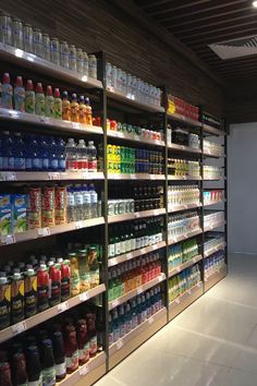 a store filled with lots of different types of drinks and juices on the shelves