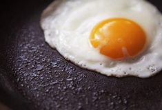 an egg is fried in a frying pan with water droplets on the bottom and sides