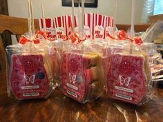 several packages of cookies wrapped in plastic on top of a wooden table with red and white striped bags