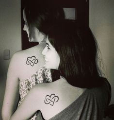 two girls with matching tattoos on their backs