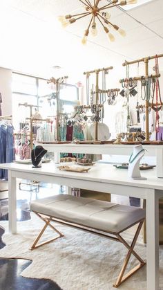 a white table sitting in front of a mirror with jewelry on it's shelves