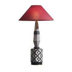 a table lamp with a red shade on it's base and an intricate design