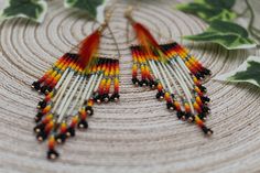 Elegant and dramatic is what comes to mind with these show stoppers.  The long Porcupine quills popping off the black background and fire colours mixed with the movement of the matching feathers and the glisten of the gold tone accents and hardware they're truly show stopping. Unique Fringe Beaded Earrings For Festivals, Festival Beaded Earrings With Fringe, Unique Fringed Beaded Earrings For Festivals, Porcupine Quill Jewelry Diy, Porcupine Quill Jewelry Native Americans, Porcupine Jewelry Quill, Beading With Porcupine Quills, Beaded Porcupine Quill Earrings, Porcupine Quills