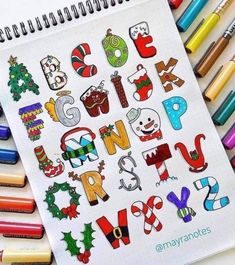 an open notebook with christmas themed alphabets and crayons