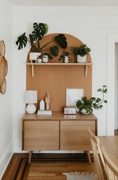 a wooden table topped with potted plants next to a wall mounted shelf