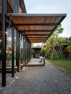 an outdoor covered walkway leading to the back of a house