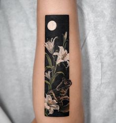 a woman's arm with a cat and flowers on it