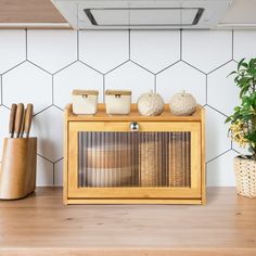 a kitchen counter with utensils on it and a potted plant next to it