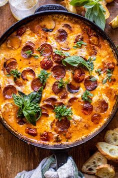 a pizza casserole with pepperoni and basil in a cast iron skillet