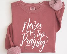 a t - shirt with the words never stop praying on it and a pair of slippers