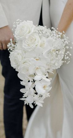 a close up of a person holding a bouquet of flowers