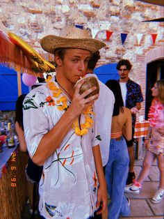 a man wearing a straw hat eating a donut