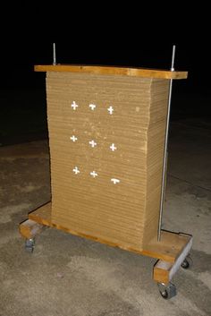 a cardboard box on wheels with crosses painted on it