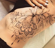 a woman's lower back tattoo with flowers on it