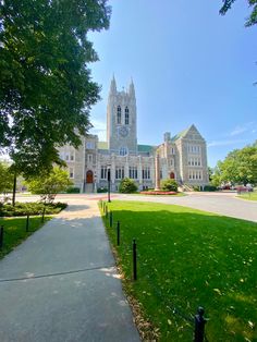 a large building with a clock tower in the middle of it's front yard