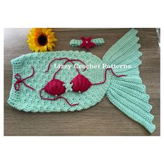 a crocheted mermaid hat and tail is shown next to a sunflower