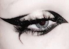 an eye with black and white makeup looks like it is in the middle of someone's eyes