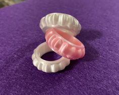 two plastic rings sitting on top of a purple surface