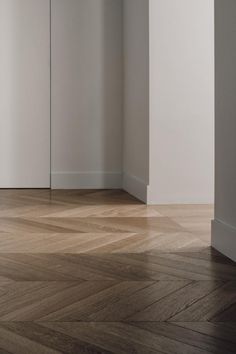 an empty room with white walls and wood floors