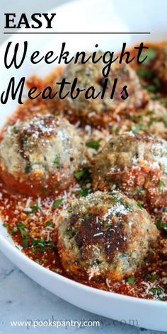 meatballs with tomato sauce and parmesan cheese in a white dish on a marble surface