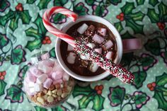 a cup of hot chocolate with marshmallows and candy cane