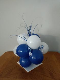 blue and white balloons in a vase on a table