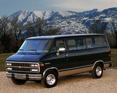 a black van parked on top of a gravel road