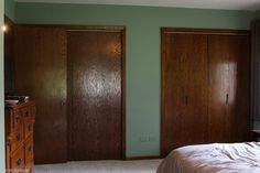 a bedroom with green walls and two wooden doors