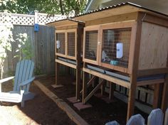 a couple of cages sitting on top of a wooden fence next to a white chair