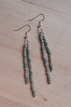 the earrings are made with silver and turquoise beads