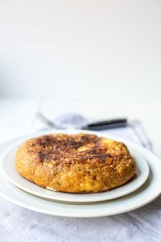 a white plate topped with a pastry on top of a table