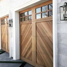 two wooden garage doors on the side of a house