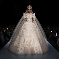 a woman in a wedding dress on the runway