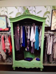 a green cabinet with clothes hanging on it