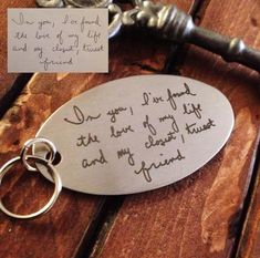 a keychain with a note attached to it sitting on top of a wooden table