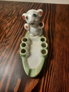 an elephant figurine sitting on top of a wooden table with holes in it