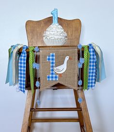 a baby's first birthday banner on a wooden chair