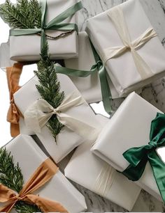 several wrapped presents with green and white ribbons on them, tied in twine bowes