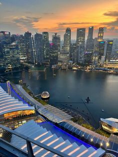 an aerial view of the city skyline at night with its lights on and water in front of it