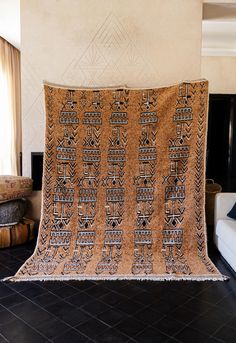 a living room with black tile flooring and a large brown blanket on the wall