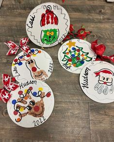 four christmas ornaments on a wooden floor