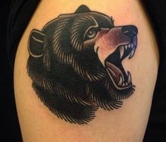 a black bear tattoo on the right arm and shoulder, with its mouth wide open