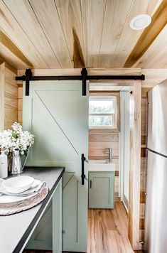 a kitchen area with wooden walls and flooring