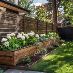 a wooden planter filled with lots of white flowers