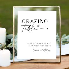 a table with candles and a sign that says, grazing table please grab a plate and help yourself