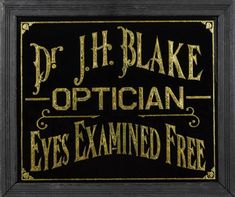 a black and gold framed sign that says dr j h blake optician eyes examined free