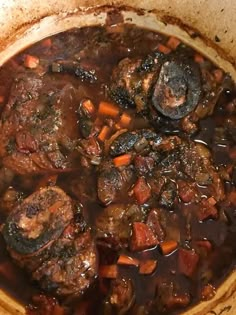 a pot filled with meat and vegetables on top of a stove