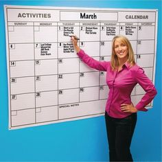 a woman standing in front of a calendar