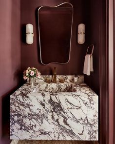 a bathroom with marble counter top and purple walls